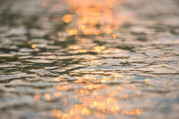 Abstract sunlight reflective on water background, Lights bokeh on water surface at sunset nature summer or spring ocean sea
