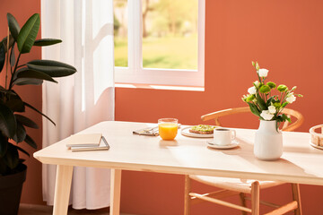 Breakfast food and flowers on table