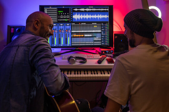 Musicians producing music in home recording studio