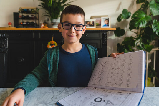 Young Boy with Glasses Showing Homework