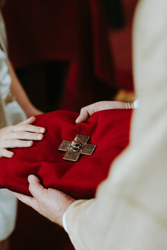 Laying hand on red cushion with cross in church