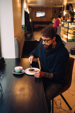 Young man eating dessert in cafe