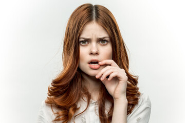 Fototapeta premium charming red-haired woman holding hand near face cosmetics studio close-up