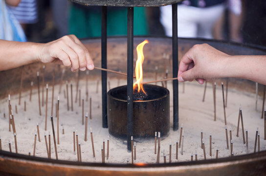 Crop people with incense sticks for prayer