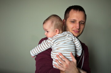 Father sitting on a sofa and holding cute little baby