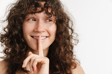 Fototapeta na wymiar Half-naked curly woman smiling and showing silence gesture
