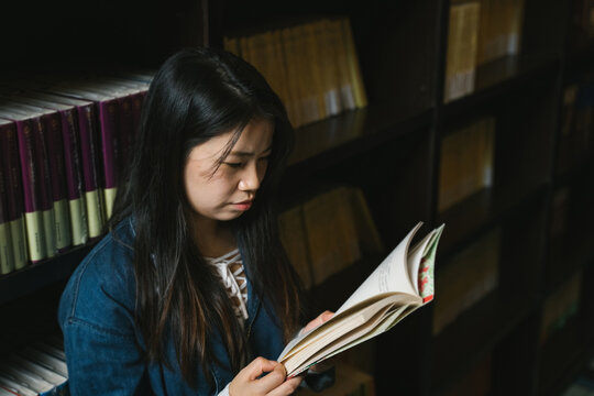 Young woman reading in the library