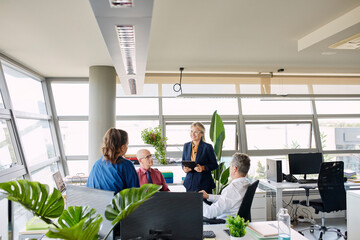 Co-workers talking in office