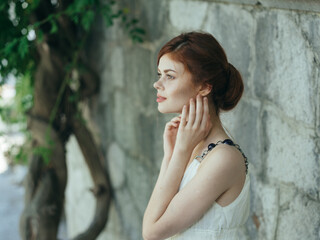 Naklejka premium Woman in white dress outdoors green leaves close-ups fresh air