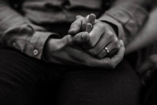 monochrome image of two people holding hands