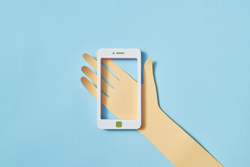 Papercraft hand holds handmade smartphone frame.