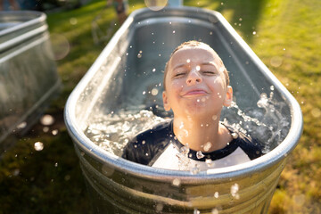 Smiling boy splashes in pool