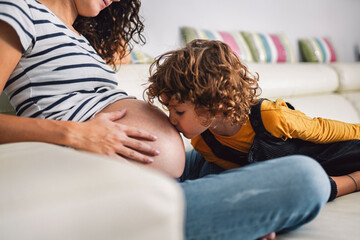 Boy kissing his pregnant mother's belly