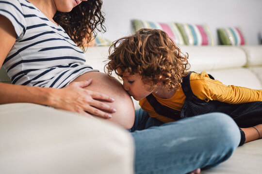 Boy kissing his pregnant mother's belly