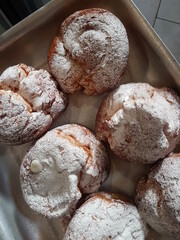 freshly cooked profiteroles sprinkled with sweet white powder