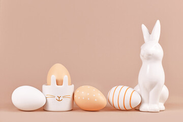 Natural colored Easter eggs with simple stripes and dots pattern with bunny shaped egg cup and...