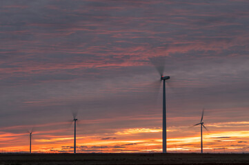 Windmills under cloudy sunset sky