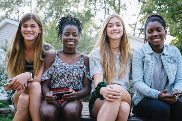 Group of diverse teenage girls with mobile devices