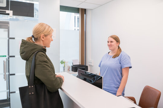 Woman Talking With Clinic Receptionist