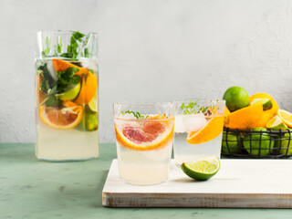Fresh summer citrus drink with ice on green