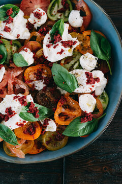 Tomatoes dish with mozzarella, basil and herbs