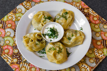 A traditional Asian steamed hot dough dish. Large dumplings on a plate.