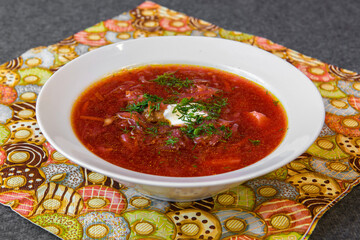 Red Borsch soup in a plate. A plate with soup on the dining table. 