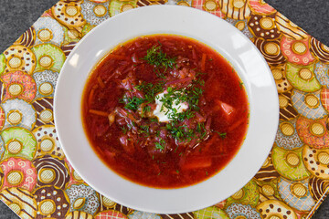 Red Borsch soup in a plate. A plate with soup on the dining table. 