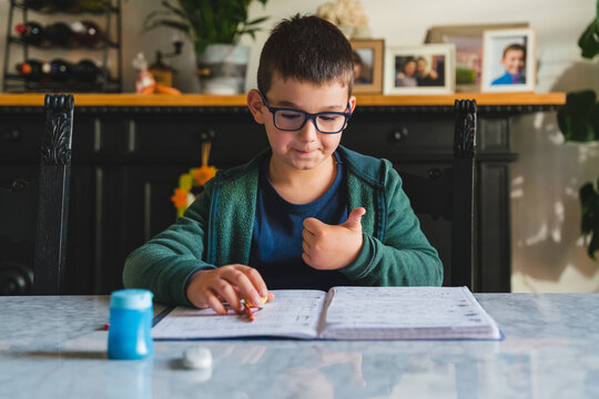 Focused Young Boy with Glasses doing Homework