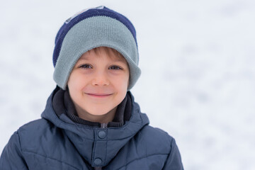 Fototapeta na wymiar Winter portrait of little boy on a freezing day. Winter fun, kid winter playing -cute boy has a fun in snow