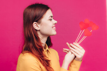 Obraz na płótnie Canvas pretty woman in shirt holding heart on stick on pink background Copy Space