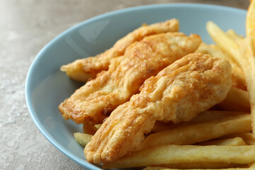 Plate with fried fish and chips, close up