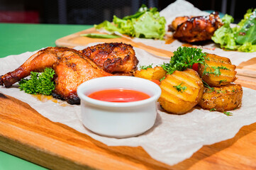 Juicy BBQ chicken leg quarters with fried potato. Food to go
