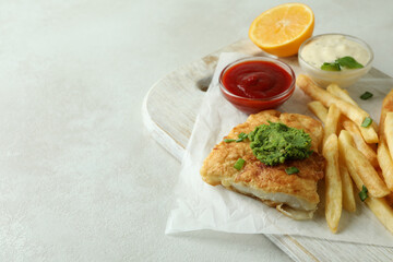 Concept of tasty eating with fried fish and chips on white textured table
