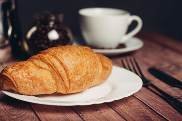croissants in a plate a cup with a drink a meal dessert snack