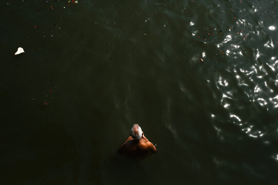 A Man Praying To Sun in the Ganges river Of Varanasi, India