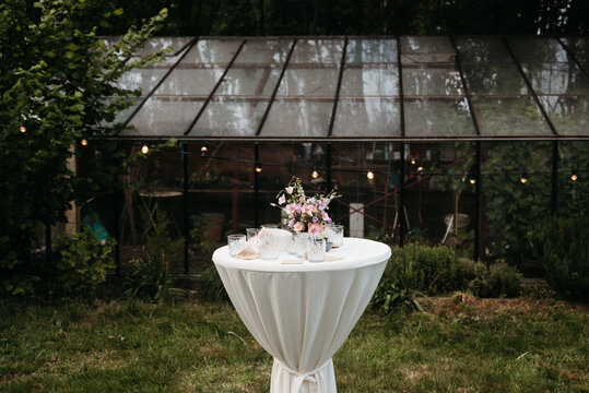 standing table in front of a conservatory with string lights