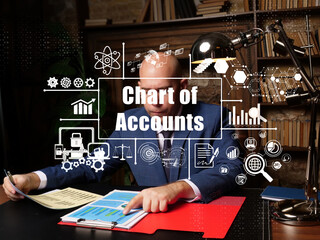 Business concept about Chart of Accounts with inscription. Young businessman reading paperwork at desk in office on background.