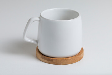 a white cup on a wooden stand on white background