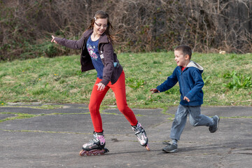 Brother chases sister on roller skates. Playing Outside on Family's Day. I'm Going to Catch You