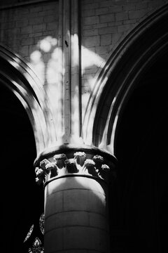 monochrome image of a pillar with sun playing around