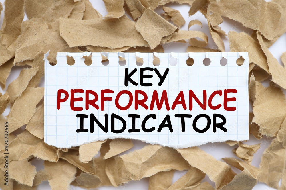 Poster kpi - key perfomance indicator. text on white paper over torn paper background.