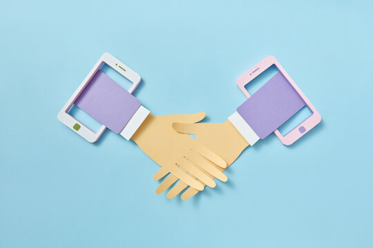 Two businessman's hands from paper greeting each other.