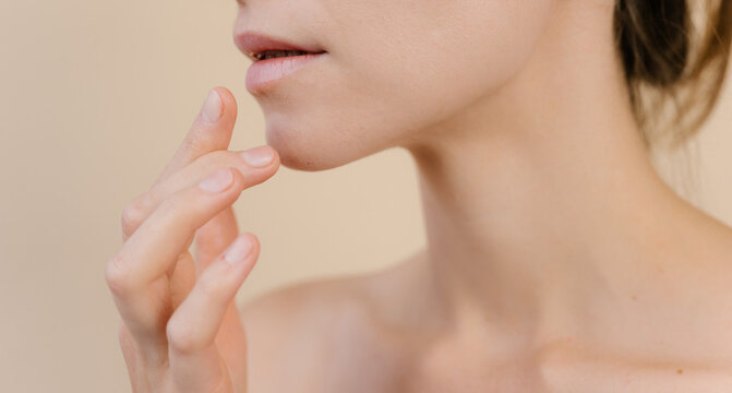 Charming woman applying lip balm in studio