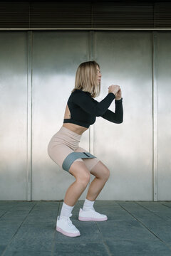 Woman doing a squat with resistance bands