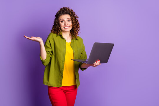 Photo of frustrated girl ceo worker work laptop fix dilemma get worse shrug shoulders wear green shirt pants trousers isolated over purple color background
