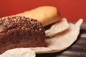 flour products rye bread on packaging and wooden table knife red background
