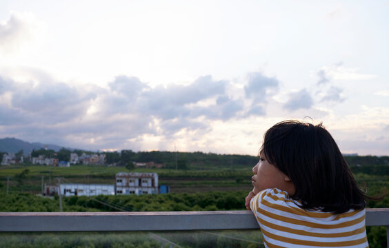 A little asian girl lying on the railing watching the scenery from afar, On the journey