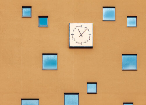 Abstract building facade with windows and wall clock