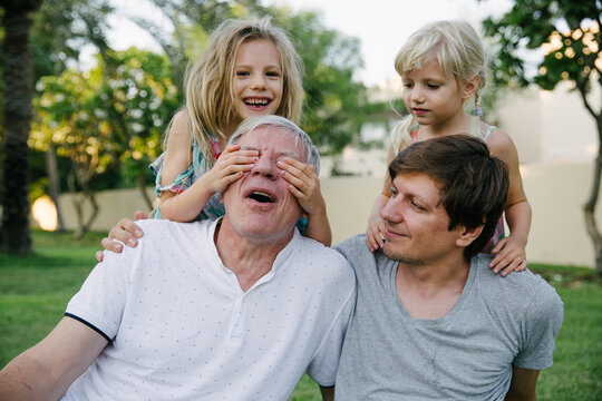 A portrait of a grandfather with his son and two granddaughters